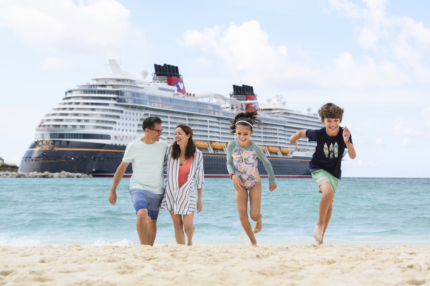 Family on Castaway Cay,  the Disney private island, with Disney Wish from Disney Cruise Line in the background