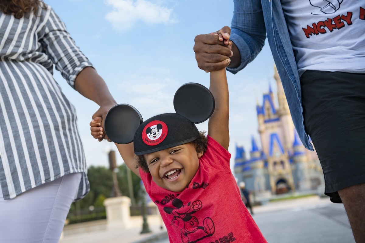 Mom, Dad, and child in Mickey Mouse Ears with Cinderella Castle in the background at Magic Kingdom® Park, Walt Disney World® Resort