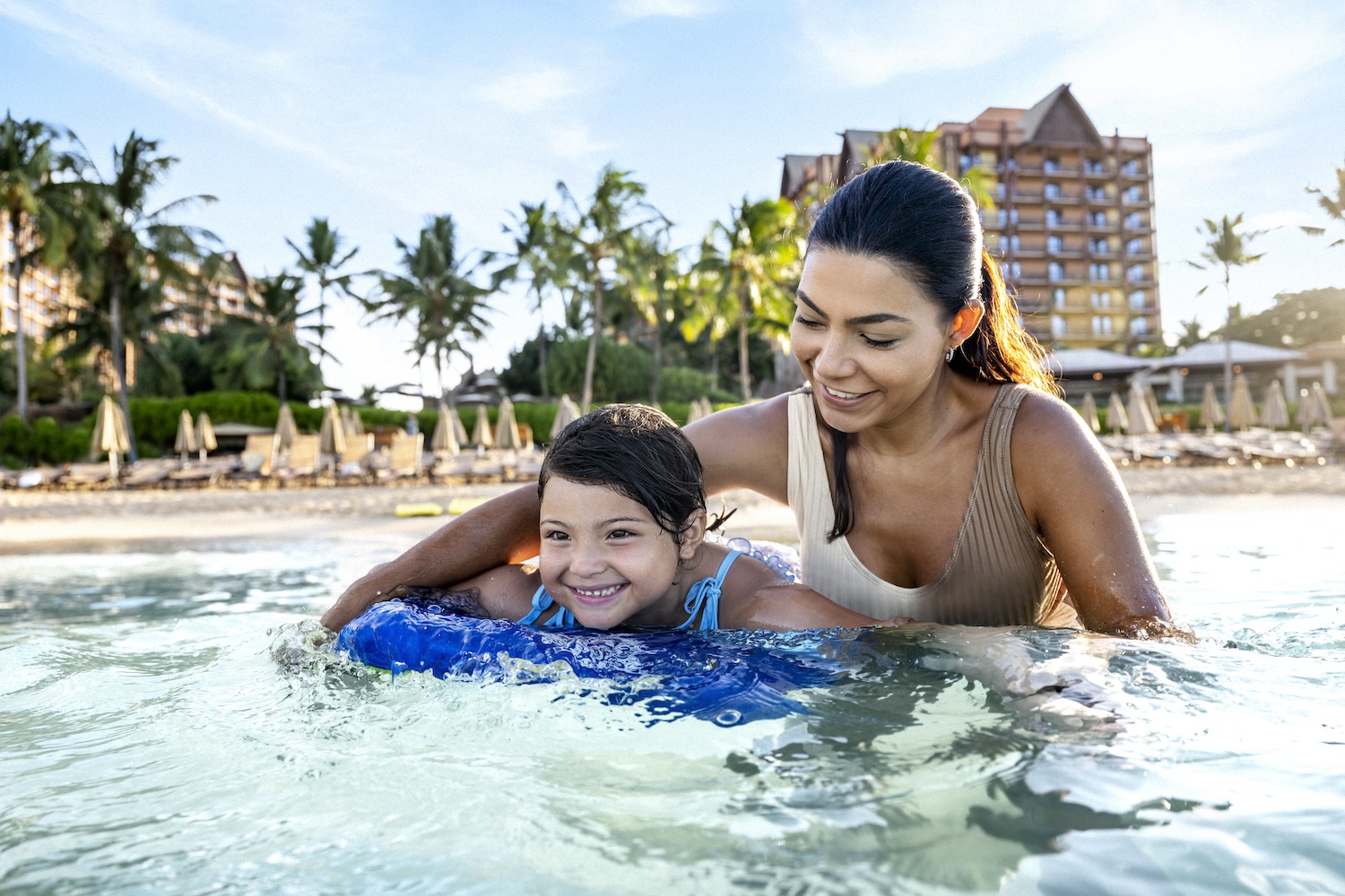 Mom and child on the beach at AULANI, A Disney Resort & Spa in Ko Olina, Hawai‘i