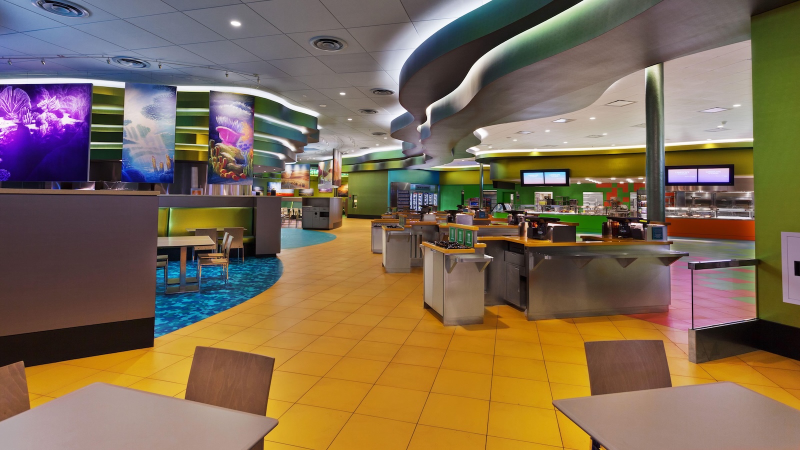 Landscape of Flavors at Disney’s Art of Animation Resort featuring colorful themed decor, multiple food stations, and seating areas with green and blue accents.