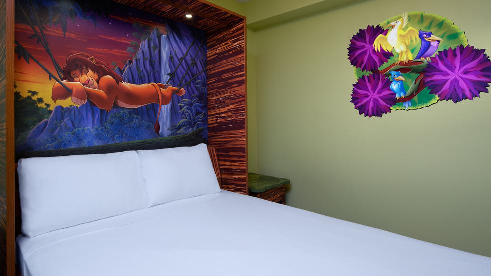 Pull-down murphy bed in Disney’s Art of Animation Resort The Lion King Family Suite featuring a Lion King-themed backdrop with Simba lounging on jungle vines, set against green walls with additional Lion King-themed artwork.